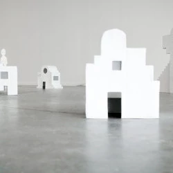 Maisons Blanches - Décors architecturaux géométriques. Recherche d'un sentiment d'architecture habitable, à la fois proche et familier, mais qui ne reflète que l'utopie de la maison vide, froide, austère, voir témoin. (dimension : variables / médiums : carton, papier mâché, peinture / date : 2022) - Crédit photo : Zachary Toulemont / Oeuvre : Anouk Glorieux 