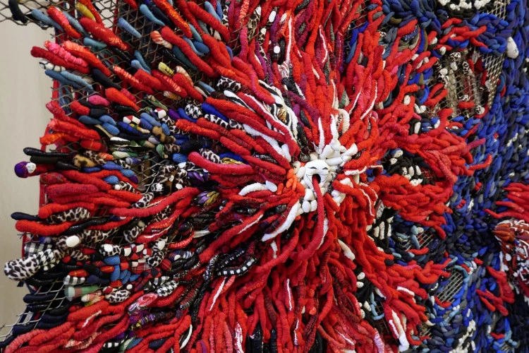 La rencontre entre l'explosif volcan qui rit et l'armada des îles-poissons - Haut-relief textile, détail. 221 x 128 x 12 cm. Vêtements et divers textiles déchirés, découpés, cousus, redensifiés, peints, fixés sur métal déployé. Juillet 2025. - Crédit image Françoise Alquier 