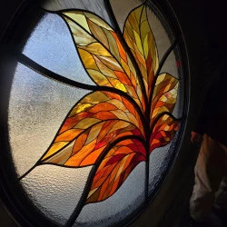 Inflorescence - Rosace (1,70 cm de diamètre) réalisée pour le Mas Pams à Bompas, inauguré en mai 2026 (verres américains et verres imprimés, cive, montage plomb et montage Tiffany, support acier ouvragé Yannick Goût - Maya Reich 