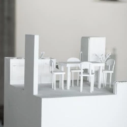 Interiors 1 - Kitchen - Cette oeuvre questionne la mémoire mais surtout, qu'est-ce que l'on garde d'un souvenir. Comment faire le tri entre éléments réels qui existent pleinement et l'image parfois étonnamment fausse que l'on retient ? Ici, les images physiques d'une maquette de cuisine sont accompagnées d'un enregistrement audio qui retrace un souvenir précis. Les enregistrements qui défilent laissent paraitre un certain goût de déjà-vu et d'incertitude. (dimension : 160 x 32 cm / médiums : carton, médiums, peinture, audio / date : 2023) - Crédit photo : Zachary Toulemont / Oeuvre : Anouk Glorieux 