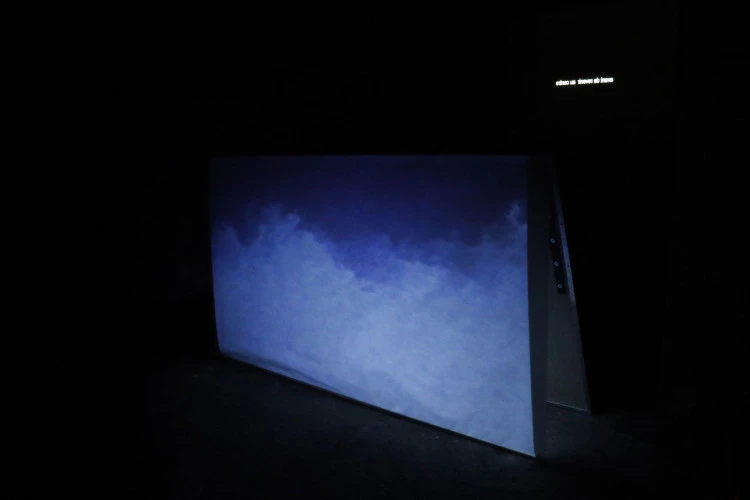 TRIÂNGULO VERMELHO - Intsallation vidéo - Travail de poésie et de traduction en collaboration avec Dulce Pascoal et Luisa Mariante - Vidéo HD, 16/9, (couleur/son), 10,56 min - Deux projections simultanées - structure papier calque et miroir en suspension 190x120cm - Crédit photo de l'artiste - vue d'installation dans le cadre de l'exposition « Frontière(s) » Maison des Métiers du cuir de Graulhet, France 
