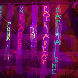 Refuge pour s'évader du patriarcat capitalisme - Sculpture : scotch réagissant à la lumière UV, collé sur des membranes plastiques à circuits imprimés récupérées en démontant des claviers d'ordinateurs obsolètes, 2026.