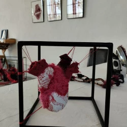 coeur bien accroché - Dans une structure en fer, dans ce cube un coeur sculpture en textile sur toile de jouy, et autres perles et broderies - Isabelle Piron 